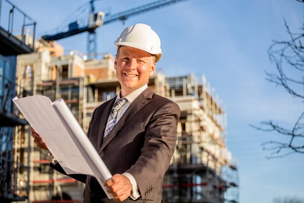 Bauleiter mit Bauplänen lizenzfreie Stockbilder