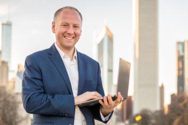 İşadamı ile laptop ofis binaları önünde