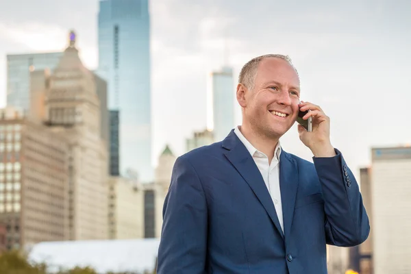 Empresário usando telefone fora dos escritórios — Fotografia de Stock