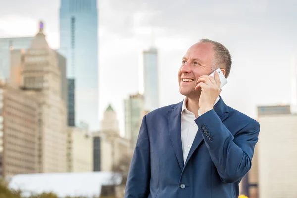 Empresário usando telefone fora dos escritórios — Fotografia de Stock