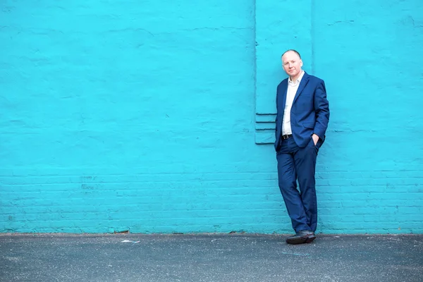 Thinking businessman and turquoise wall — Stock Photo, Image