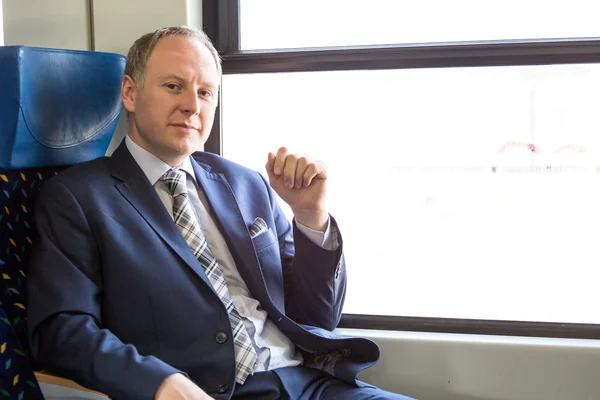 Serious businessman sitting in a train — Stock Photo, Image