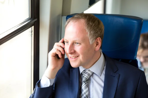 Zakenman aanroepen vanuit een trein — Stockfoto