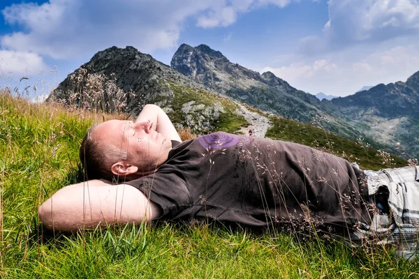 Homem descansando nas montanhas — Fotografia de Stock