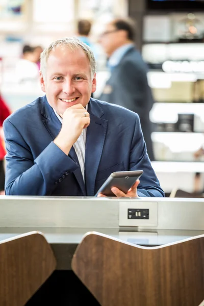 Empresário usando seu tablet no aeroporto — Fotografia de Stock