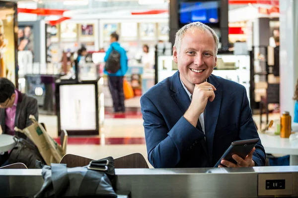 Empresário usando seu tablet no aeroporto — Fotografia de Stock