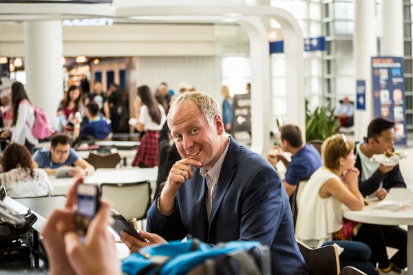 Empresário usando seu tablet no aeroporto — Fotografia de Stock