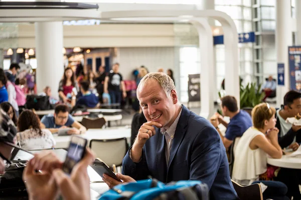 Empresário usando seu tablet no aeroporto — Fotografia de Stock