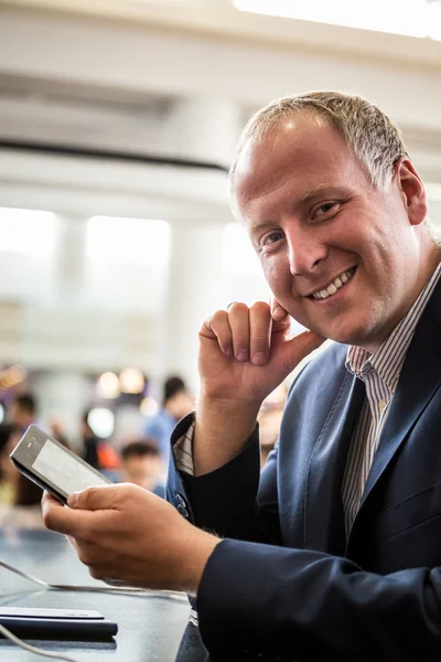 Empresário usando seu tablet no aeroporto — Fotografia de Stock