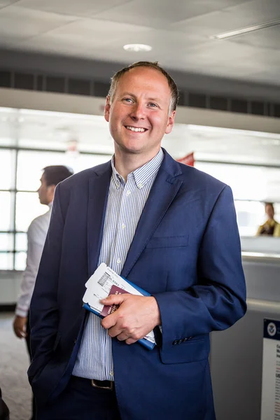 Empresário com passaporte e cartão de embarque no aeroporto — Fotografia de Stock