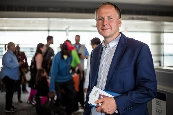 Businessman with passport and boarding pass at the airport — Stock Photo, Image