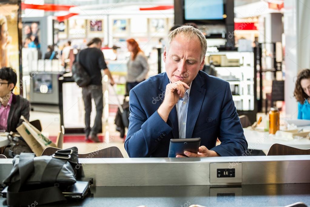 Businessman using his tablet at the airport