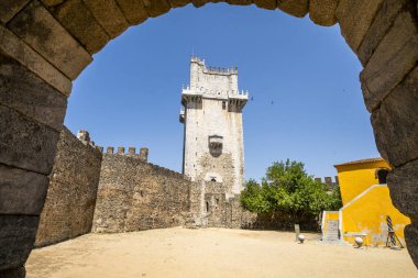 Portekiz, Alentejo 'daki Beja Kalesi' nin açık mavi gökyüzünün altındaki ortaçağ taş duvarları ve kuleleri..