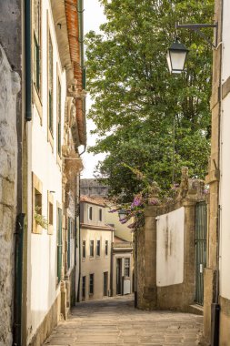 Porto, Portugal. Quiet narrow alley lined with whitewashed buildings, stone details in the historic old town