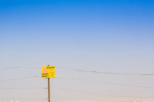 ¡Minas Peligrosas! Señal de advertencia y alambre de púas . — Foto de Stock