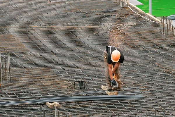 The employee works on the construction site. Performed work electric tools for cutting reinforcement.