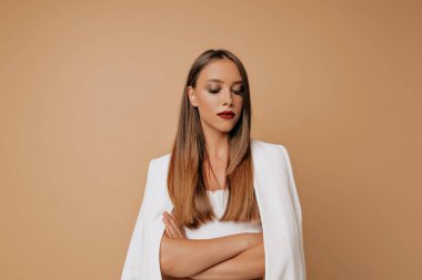 Odaklanmış, beyaz elbiseli, makyajlı güzel bir bayan kollarını izole edilmiş arka planda çapraz yapmış. Yüksek kalite fotoğraf