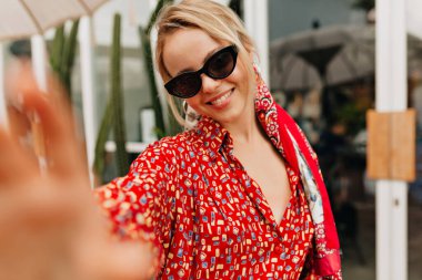 Mutlu, güzel bir kız. Selfie çekiyor ve alışveriş merkezinin önünde yürüyor. Yüksek kalite fotoğraf