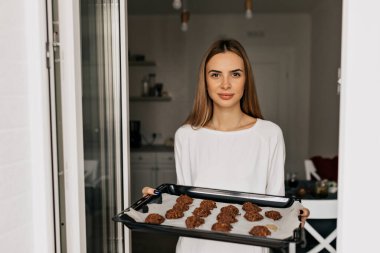 Çekici genç bayan mutfakta yemek pişiriyor. Ev yapımı kurabiyelerle deco tutan mutlu bayan. Yüksek kalite fotoğraf