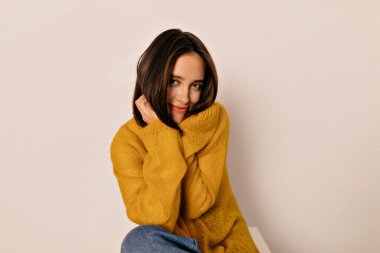 Sarı bluzlu, siyah saçlı, nazik, mutlu bir kadın. Yüzüne yakın el ele tutuşup gülümsüyor. Yüksek kalite fotoğraf