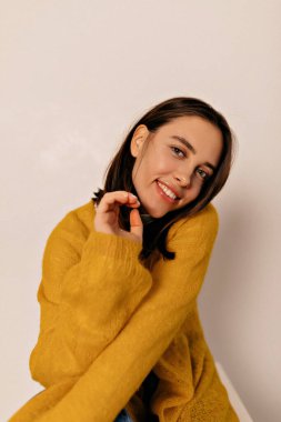 Örgü ceketli, sırıtan kısa saçlı kadın izole arka planda poz veriyor. Neşeli mutlu kız eğleniyor. Yüksek kalite fotoğraf