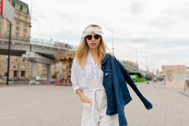 Sarışın, Avrupa 'da gezen romantik bir kadının açık hava fotoğrafı. Beyaz yaz kıyafetli zarif genç bayan setin manzarasının tadını çıkarıyor. Yüksek kalite fotoğraf