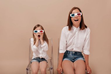 Annesiyle birlikte 3 boyutlu gözlüklerle film izleyen küçük kızın aile portresi. Şaşırmış duygularla. Yüksek kalite fotoğraf