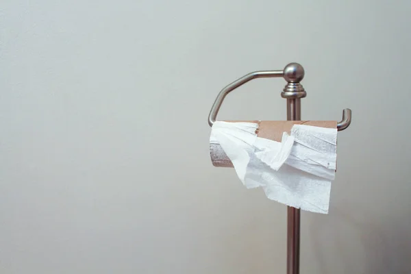 Metal stand with empty toilet paper roll