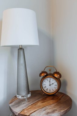 Alarm saati ve okuma lambası komodinin üzerinde. Geçmiş metni kopyala