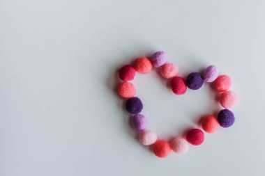 Beyaz ahşap arka planda, Anneler Günü veya Sevgililer Günü için aşkın sembolü olarak yumuşak bir kalp.