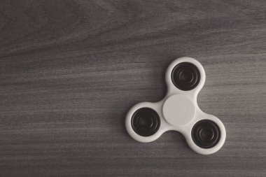 Renkli hareketli parmak döndürme stresi, ahşap arka planda endişe giderici oyuncak. Seçici odak.