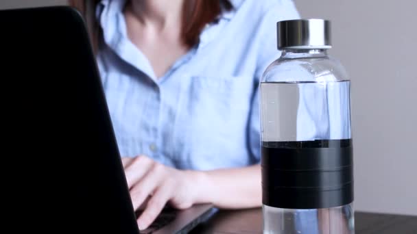 Kobieta Pracuje Laptopie Skup Się Szklanej Butelce Czystą Wodą Miejsce — Wideo stockowe