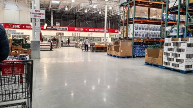 Tecrit sırasında müşteriler süpermarketten alışveriş yapıyor. Büyük bir süpermarkette gereksiz alışveriş malzemelerini bant kapatılıyor.