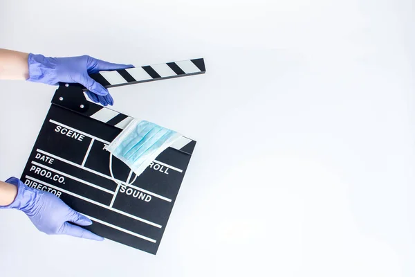 Mavi, tek kullanımlık lastik eldivenli bir kadın, elinde bir el çırpıcı tutuyor. Sinematografi üzerine salgın etkisi