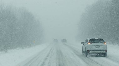 Syracuse NY, ABD - 3 Ocak 2025: Şiddetli kar yağışı ve kış hava koşulları altında araçlar karlı bir yolda ilerliyor