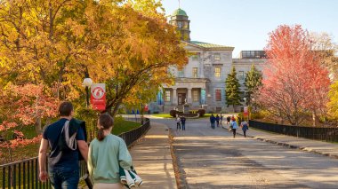 Montreal QC, Kanada - 22 Ekim 2022: McGill Üniversitesi Açık Kapılar etkinliği öğrencilerin renkli sonbahar yaprakları ve tarihi binalarla çevrili kampüs yolunda gezinmelerini içeriyor
