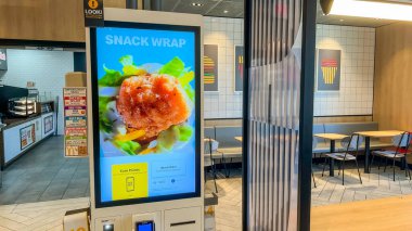 Syracuse NY, ABD - 31 Ağustos 2025: McDonald 's dijital menüsü, renkli dekorlu çağdaş bir fast food ortamında taze malzemelerle abur cubur paketini vurguluyor