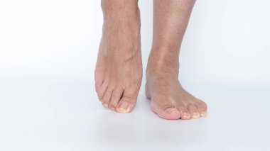 Yorgun bacaklar ve ayaklar pürüzsüz bir yüzeyde dinleniyor. Uzun bir aktivite ve hareketin ardından yaşanan rahatsızlık ve ağırlığı vurguluyor.