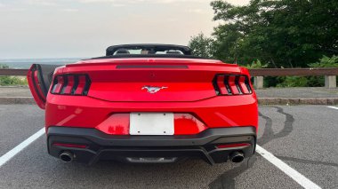 Ottawa ON, Kanada - 06 Ağustos 2025: Ford Mustang üstü açık kapılı manzaralı bir arabaya park edilmiş, parlak kırmızı rengini ve parlak tasarımını ön plana çıkarıyor