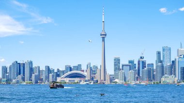Toronto ON, Kanada - 3 Temmuz 2022: Şaşırtıcı Toronto silueti CN Kulesi 'ni, modern binaları ve sakin suları sergiliyor ve canlı bir kentsel atmosfer yaratıyor
