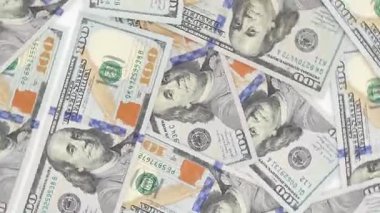 Dağınık yüz dolarlık banknotların yakın plan görüntüsü, karmaşık tasarımlar ve canlı renkler, görsel detayları geliştirmek için kamera pürüzsüzce yakınlaştırır