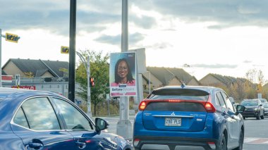 Gatineau QC, Kanada - 25 Ekim 2025: Quebec seçim kampanyası posterinde sokak direğinde gülümseyen bir kadın, şehir merkezinde araçlar ve bulutlu gökyüzü görülüyor