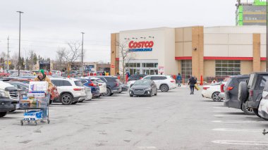 Ottawa On, Kanada - 05 Aralık 2025: Müşteri ve park alanlarında park etmiş araçların bulunduğu bir Costco toptancısının dış görünüşü
