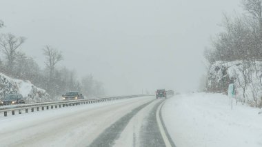 Gatineau QC, Kanada - 30 Kasım 2025: Şiddetli kar fırtınası otoyolu beyaz karla kaplıyor, araçlar yolda görünüyor, ağaçlar yan yana diziliyor