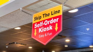 Skippers VA, ABD - 27 Şubat 2026: McDonald 's self-order büfe tabelası bir fast food restoranının tavanından müşterileri büfeye yönlendiren kalın renkler ve oklarla gösteriliyor
