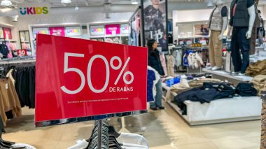 Gatineau QC, Kanada - 14 Aralık 2025: Perakende mağazasının iç mekanı, giysi satışlarında 50 indirimli satış olduğunu gösteren açık kırmızı bir tabela sergiliyor.