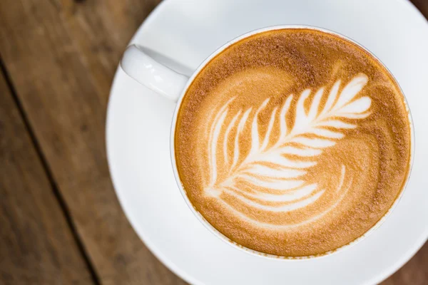 Tasse de café chaud latte art sur table en bois — Photo