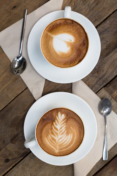 Tahta masada bir fincan sıcak latte sanat kahvesi.
