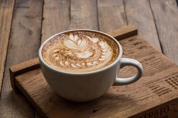 Κούπα ζεστό καφέ latte art σε ξύλινο τραπέζι — Φωτογραφία Αρχείου