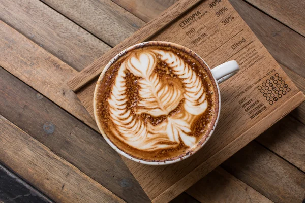 Чашка кофе с горячим латте на деревянном столе — стоковое фото